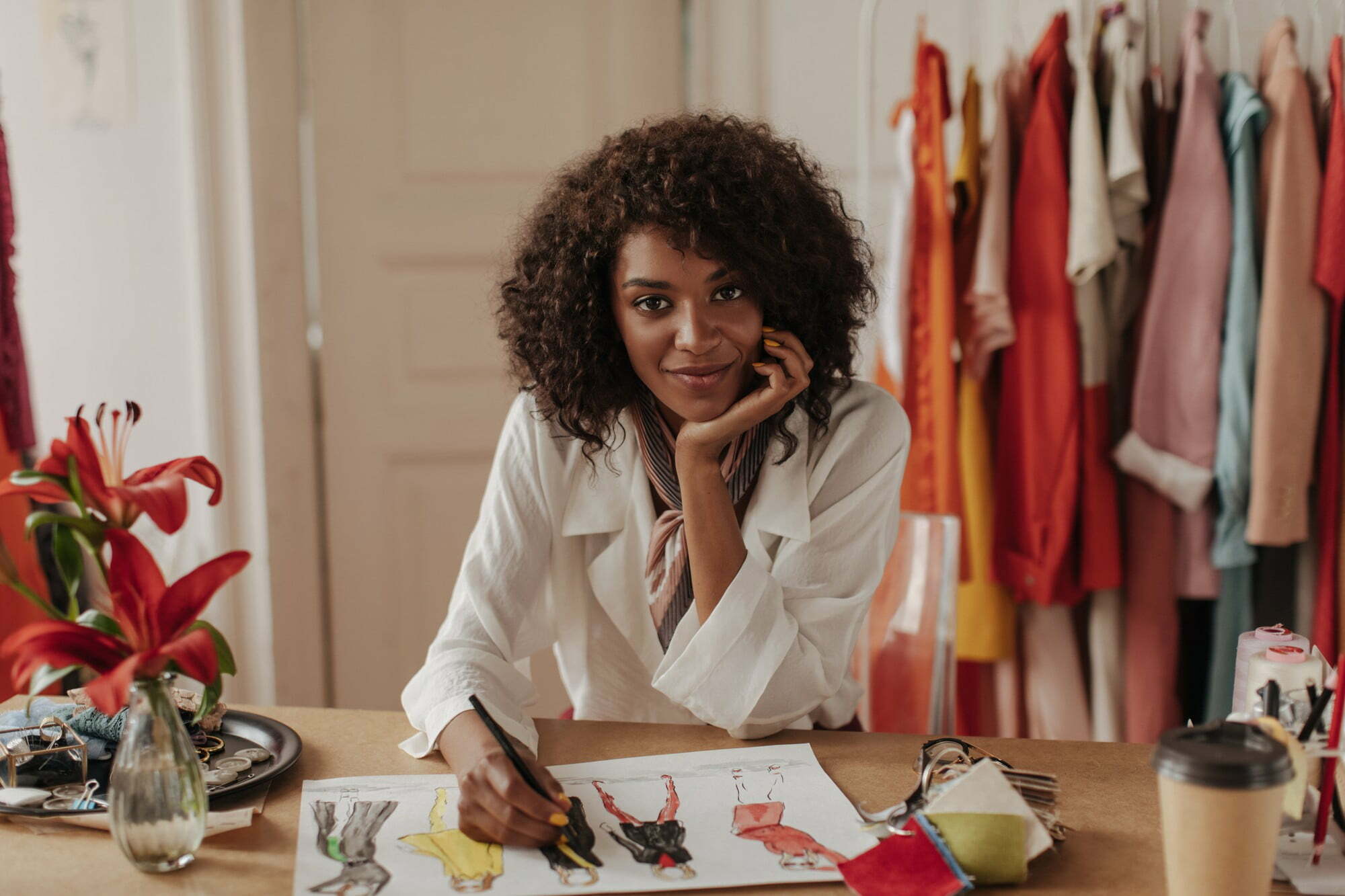 beautiful young dark skinned curly brunette woman white blouse looks front leans table designs stylish clothes
